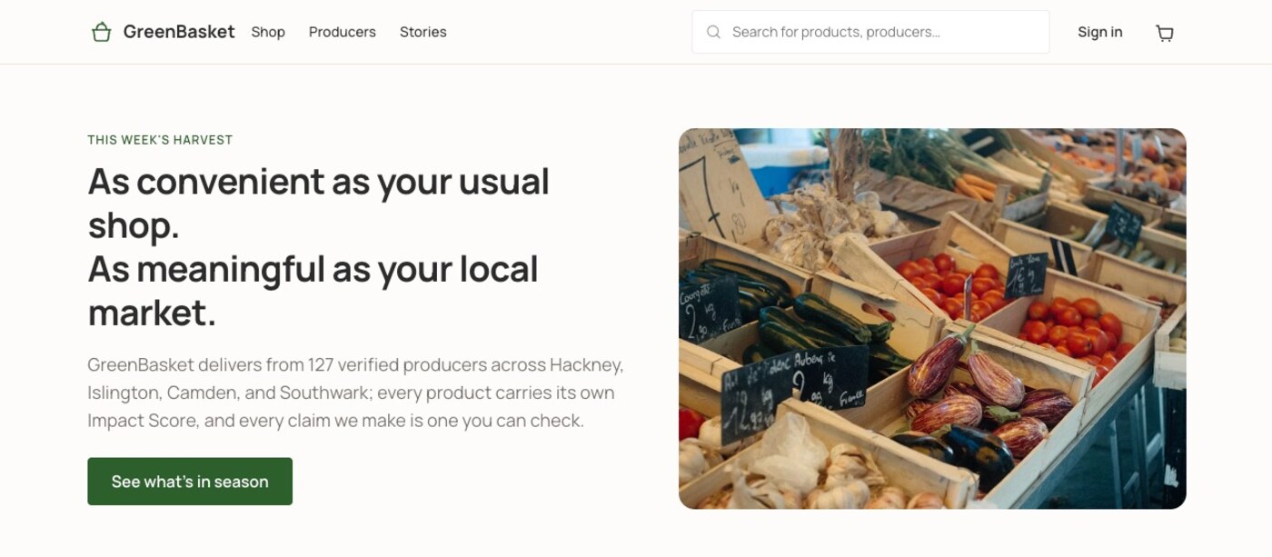 The GreenBasket homepage hero: a headline reading “As convenient as your usual shop. As meaningful as your local market,” body copy citing 127 verified producers across four London boroughs, a “See what's in season” button, and a photograph of a market produce stall.